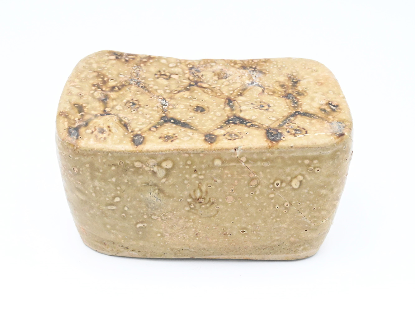 Ceramic bock-shaped headrest with diamond and dot pattern on the top