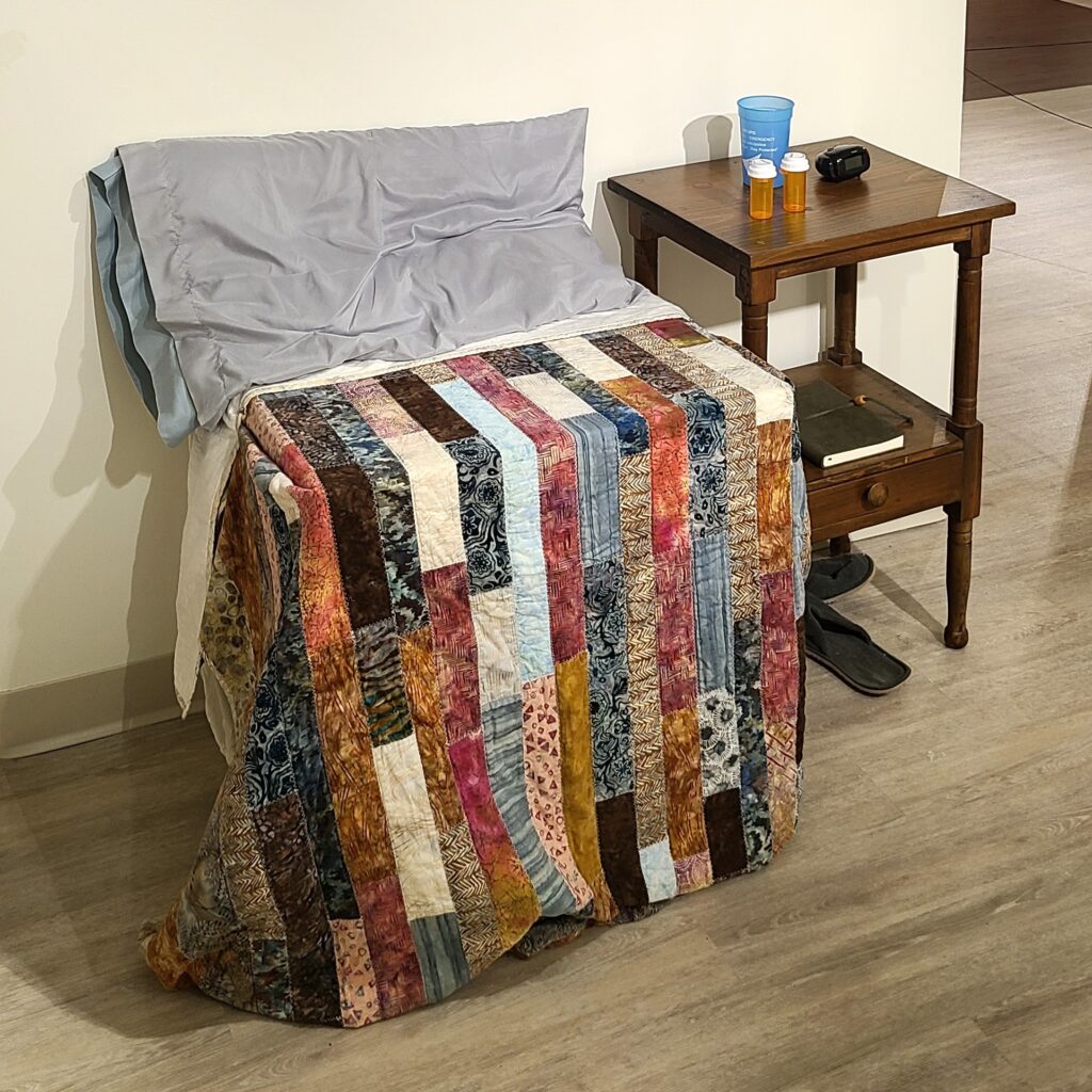 diorama showing American style bed and bedside table