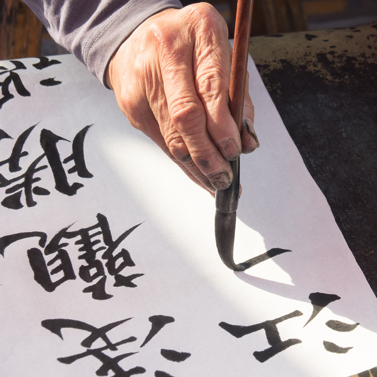 hand with brush painting chinese symbols