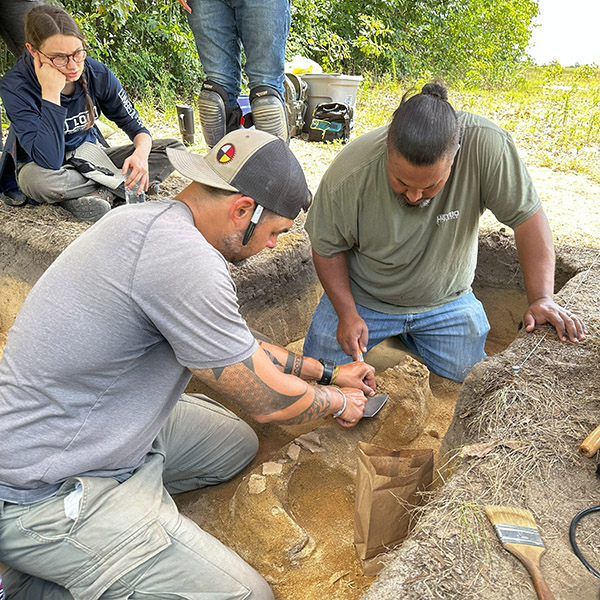 Two men digging at an archaeological site