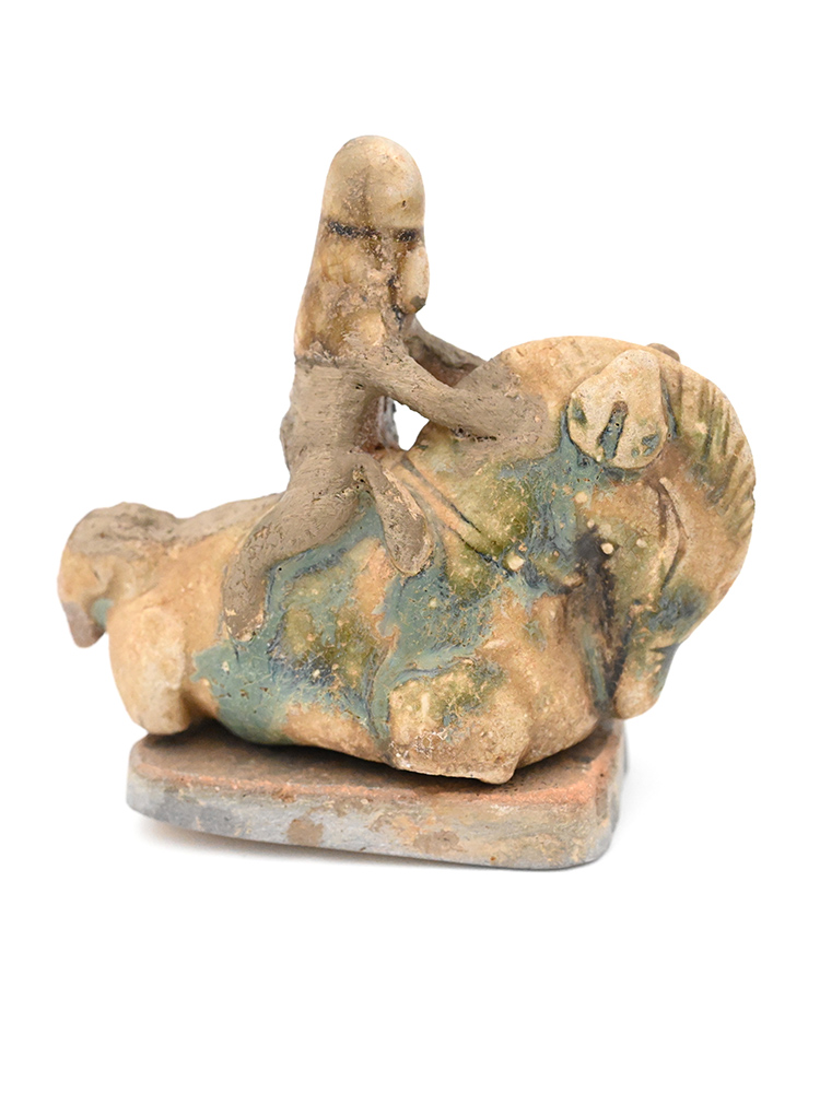 Miniature figure of a person wearing a hat riding a horse