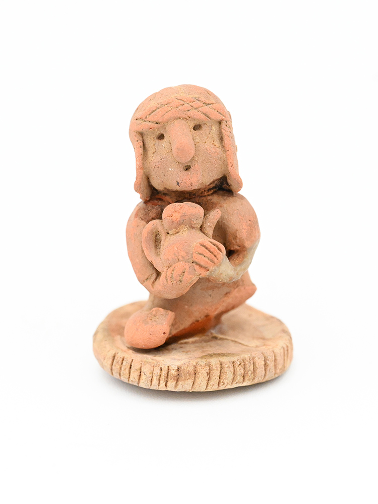 Ceramic figure of a person in a round hat with flaps