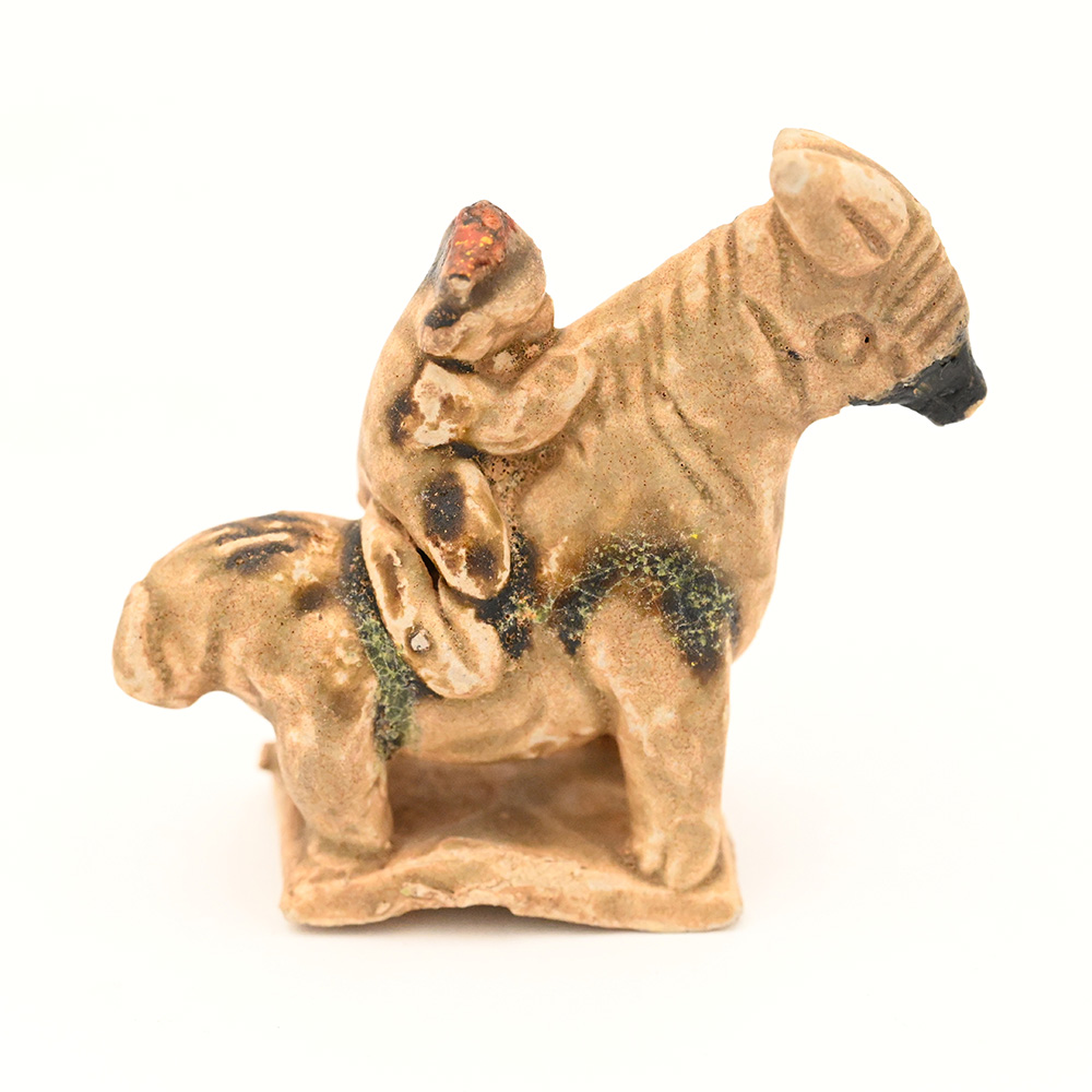 ceramic figure of a monkey riding a horse