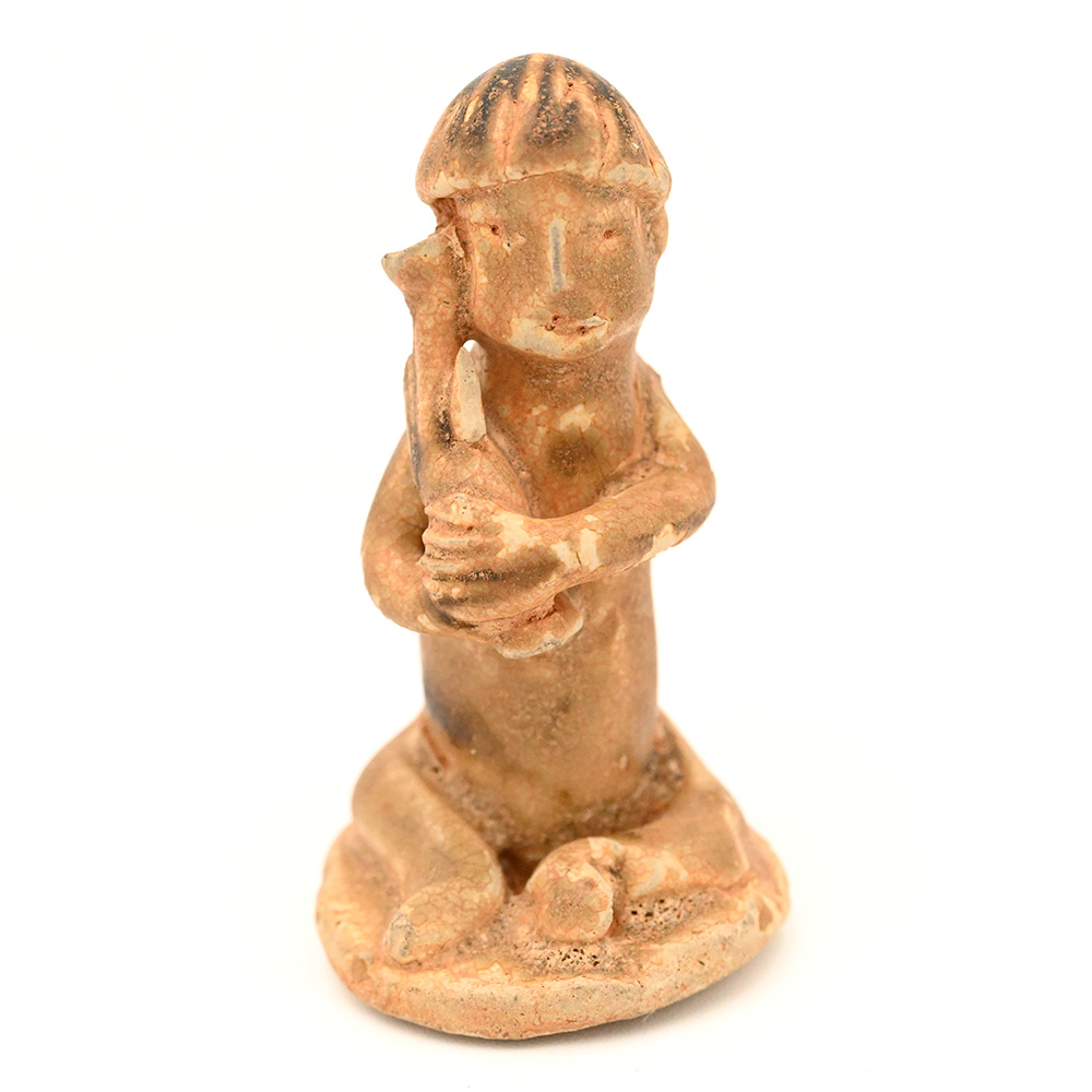 miniature ceramic figure of a man wearing a hat