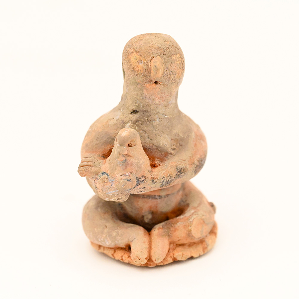 miniature ceramic figure of a man holding a bird