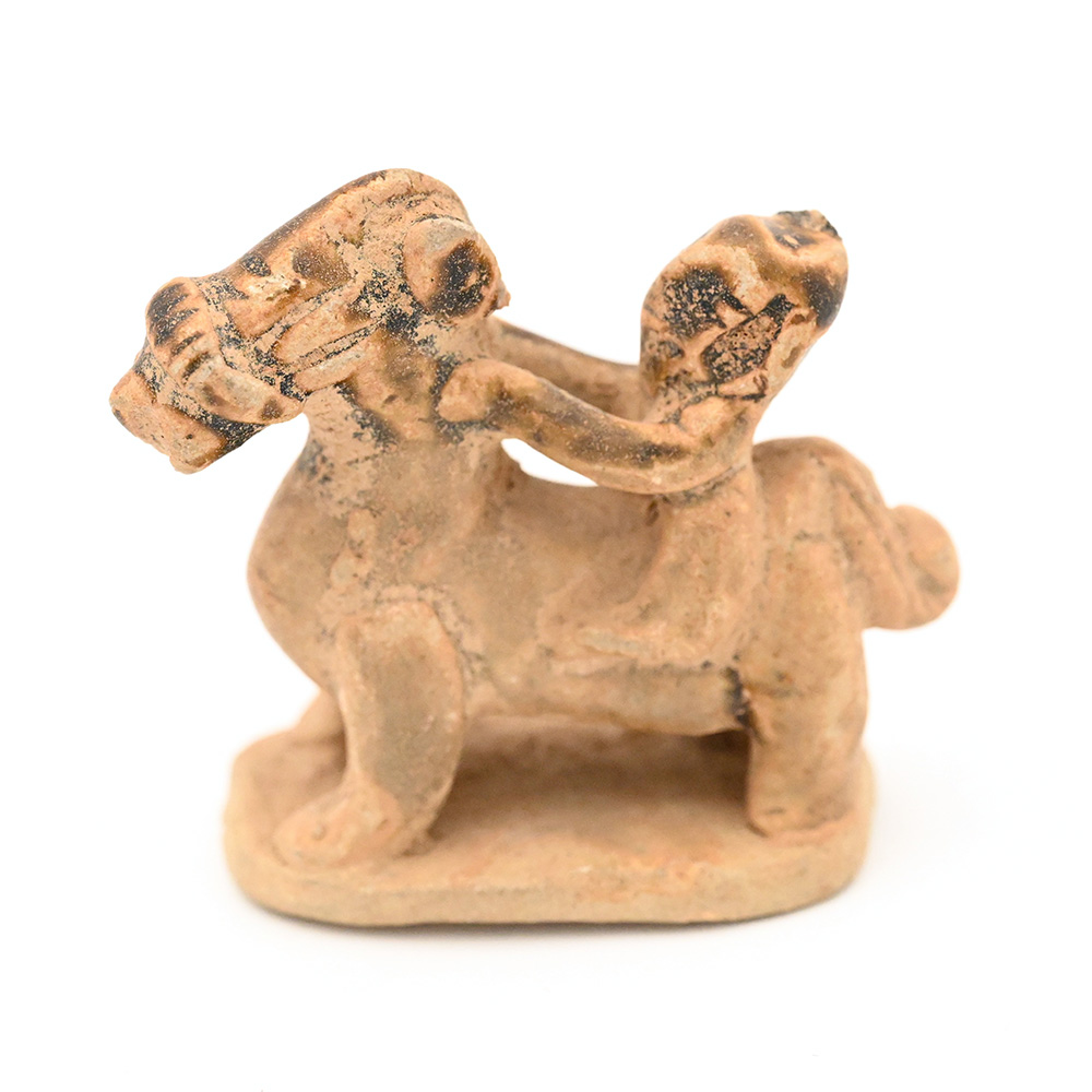 miniature ceramic figure possibly showing a monkey riding a horse