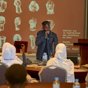 A man speaks to students at a table