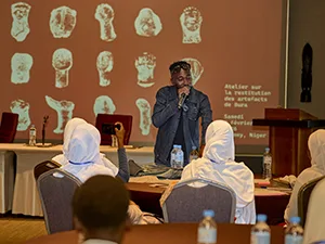 A man speaks to students at a table