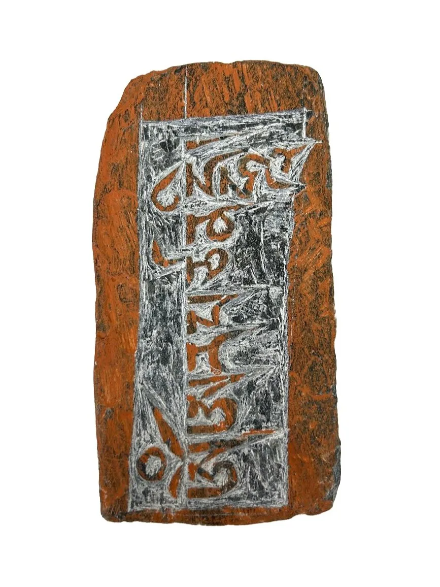 reddish stone inscribed with Sanskrit writing