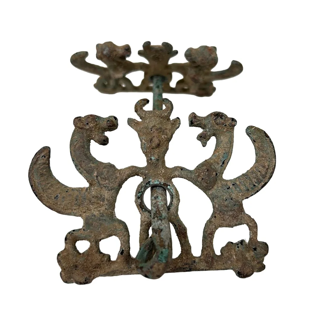 Metal horse bit with ends decorated with mythical animals