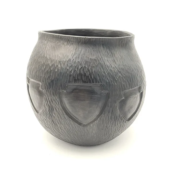a dark brown ceramic pot with an incised arrowhead design