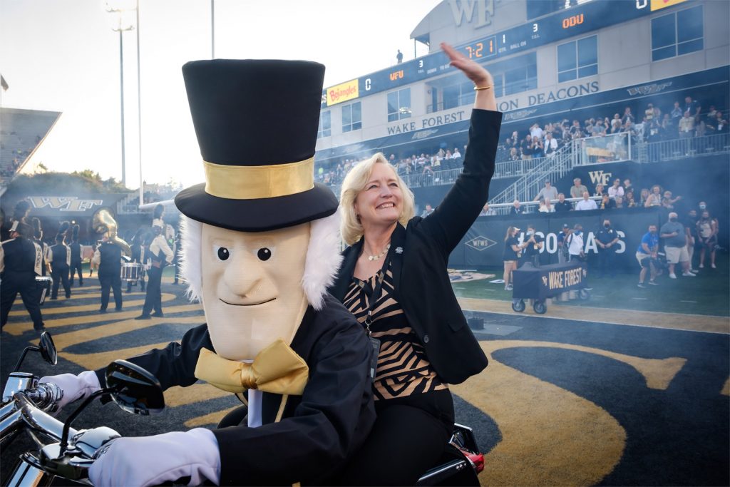 New Wake Forest President Susan R. Wente is the “Open the Gate” honoree at the opening game of the Demon Deacons football team, at Truist Stadium on Friday, September 3, 2021. Wente rides onto the field with the Demon Deacon mascot before the game