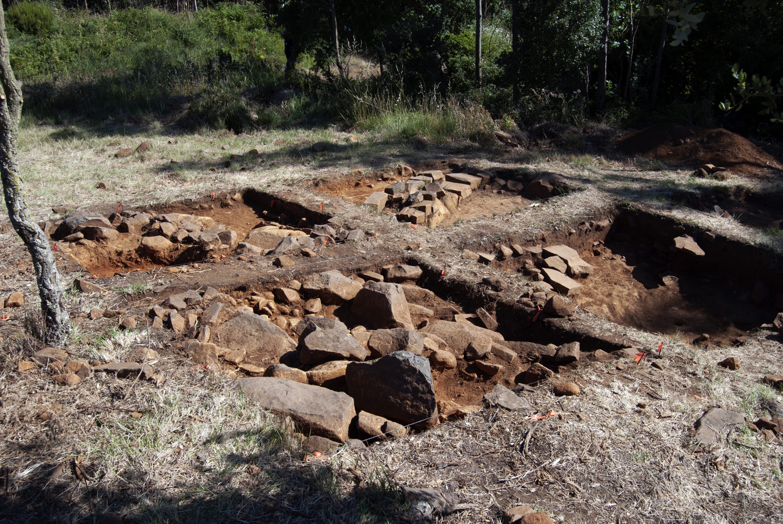 Excavation site square grid with large boulders in each section of grid,