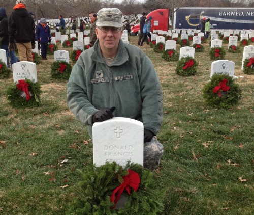 Col. Waters places a holiday wreath at a gravesite in Arlington National Cemetery.