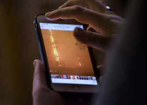 In Forest Ranch, Calif. on 1/27/19, Amy Ahl-Wright looks at images on her cel phone of the Camp Fire which destroyed her family's home in Paradise, Calif.
