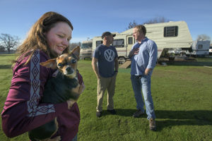 Zada Evans 18, left with her dog "Little Bit," and her father Thomas Evans talk with Woody Faircloth of Denver, Col. in Durham, Calif. on 1/27/19. Property owners Kim and Henry Young have allowed about a dozen families displaced by the Camp Fire – including the Evans – to live on their property in RVs donated through the efforts of Faircloth.