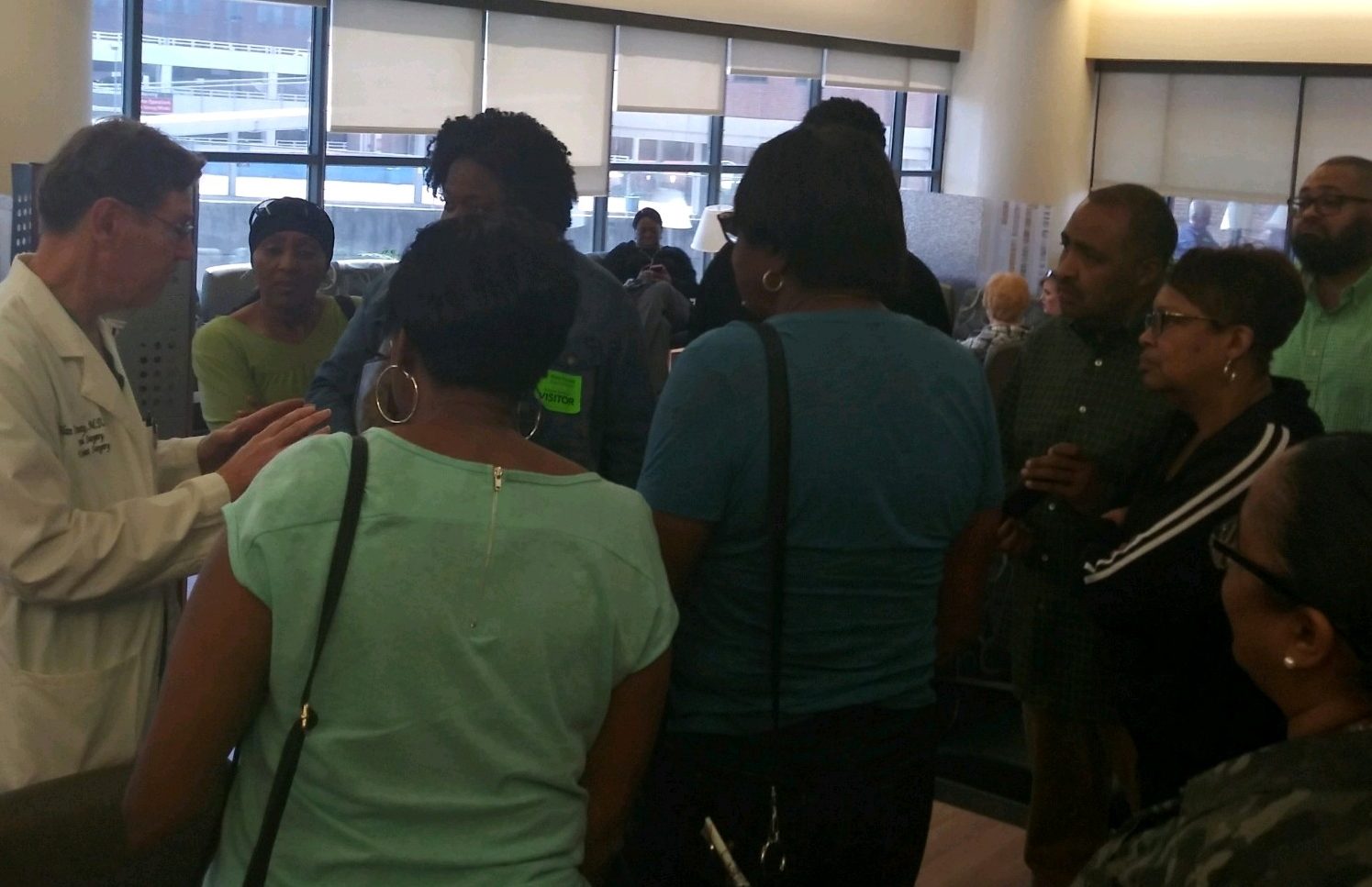 A crowd of friends surround a doctor at the hospital to hear how Anthony and Vinnie are doing.