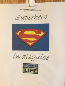 a sign says Superhero in disguise with a Superman logo