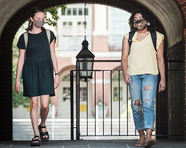 Wake Forest students and recent graduates demonstrate a socially distanced and properly masked campus, on the campus of Wake Forest University, Tuesday, July 28, 2020. Ellie Bruggen (’20) and Monet Beatty (’20) talk outside Davis Residence.