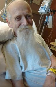 Coalette Psuik's father, Philip, with a very long white beard is in a hospital gown. She cared for him through the cancer that took his life in 2016.