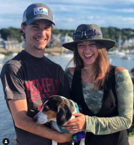 Alex Koblan ('13), her husband, Bart Johnston ('12), and their dog, Luna with the bay behind them.
