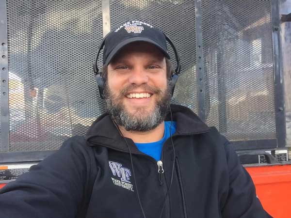 Chris Hudson (MA '18) in a ball cap, Wake Forest sweatshirt and headphones during his filming and directing of "The Mayberry Effect" documentary.