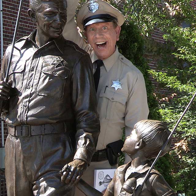 Actor David Browning mugs for the camera with the bronze statue of Andy and Opie in Mount Airy, says he is "The Mayberry deputy" because no one can replicate Don Knotts' Barney Fife. But his comedic, improvised interactions with fans is classic Barney.
