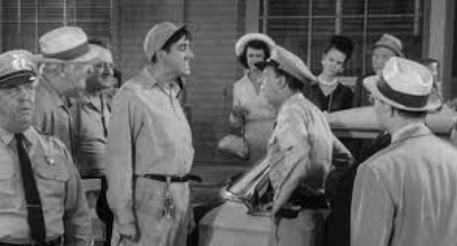from a clip of "The Andy Griffith Show" episode "Citizen's Arrest" with town mechanic Gomer Pyle facing off with Deputy Barney Fife in a crowd of Mayberry onlookers.