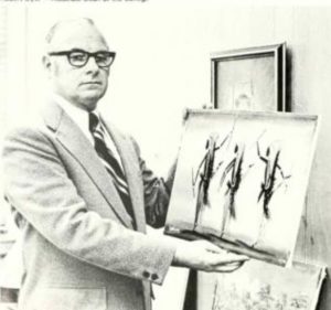Robert A. Dyer (P ’89), a religion professor and associate dean of the College, stands in front of artwork in this black and white photo. He is wearing a suit, tie and black horn-rimmed glasses.