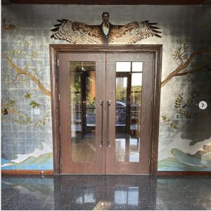 A mural over and around a door by Christopher Holt in the narthex of a chapel at Dorothea Dix Park in Raleigh shows a Black man's face with the outstretched wings of a bird