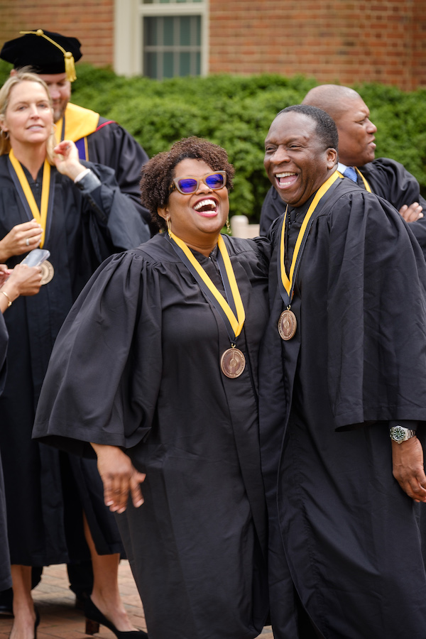 Alumni delegates pose and laugh outside Wait Chapel before inauguration.