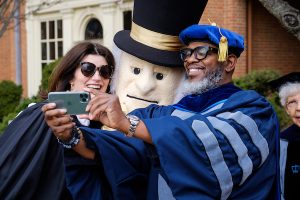 Faculty members pose for a selfie with the Demon Deacon on the Quad.