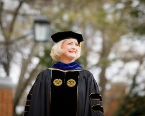 Dr. Susan Wente smiles on the Quad wearing her presidential regalia.