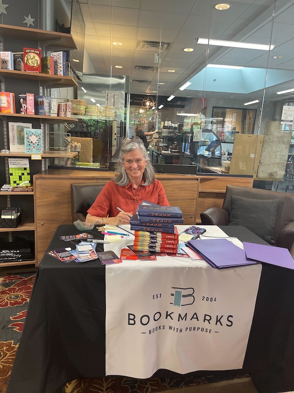 Laura Elliott sits at a book signing table at Bookmarks in Winston-Salem
