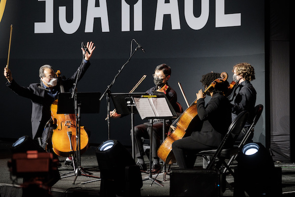 Yo-Yo Ma raises his hands as he plays cello with a student quartet at Joel Coliseum