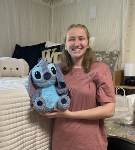 Abigail holds Stitch doll with Wake Forest pillows in the background