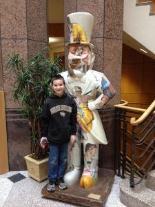 Young Luke Berry poses in front of a Deacon statue in Benson University Center