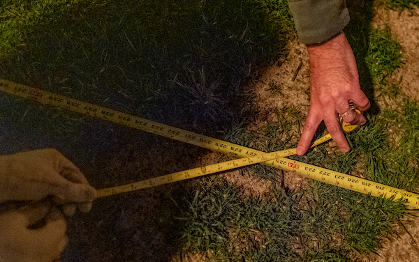 Hands form a tape measure in an "X" formation