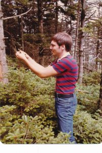 Young Frank Telewski working with a pine tree in the woods