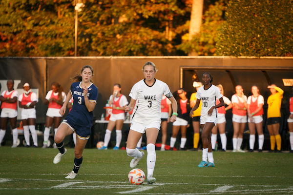 A women's soccer player wearing number 3 kicks the ball during a game against Notre Dame.