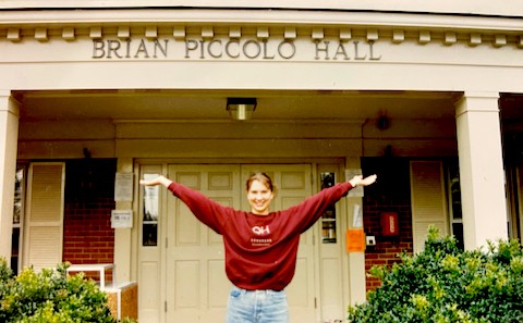 Stacy Wentworth with arms extended in front of Piccolo Hall when she was an undergrauate student at Wake Forest