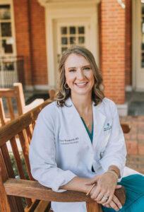 Dr. Stacy Wentworth ('00, MD '94) in a chair on campus