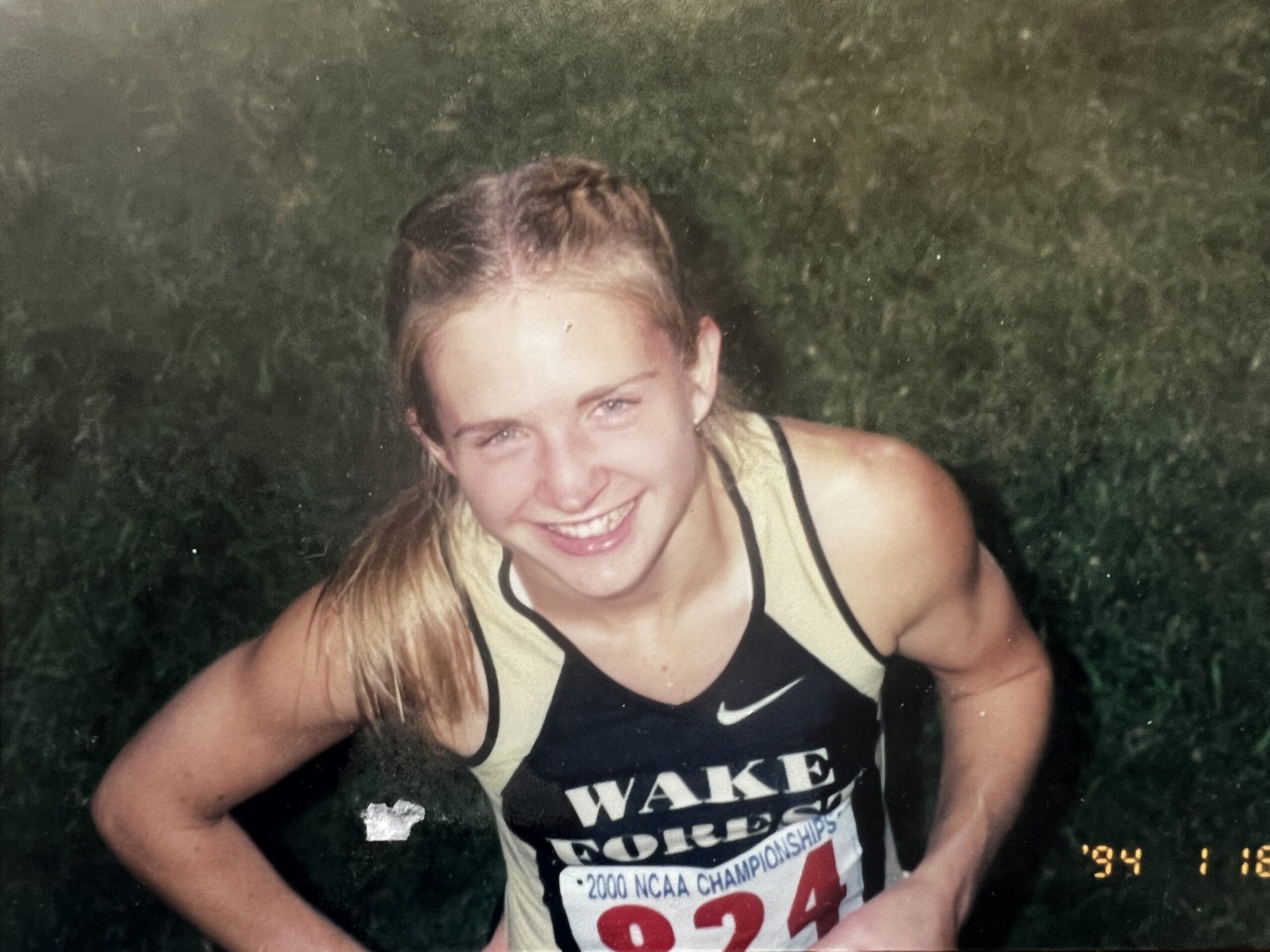 Student Jill Snyder Kerr ('00, MAEd '01) looks up in the camer in her running uniform, her parted in the middle and braided.