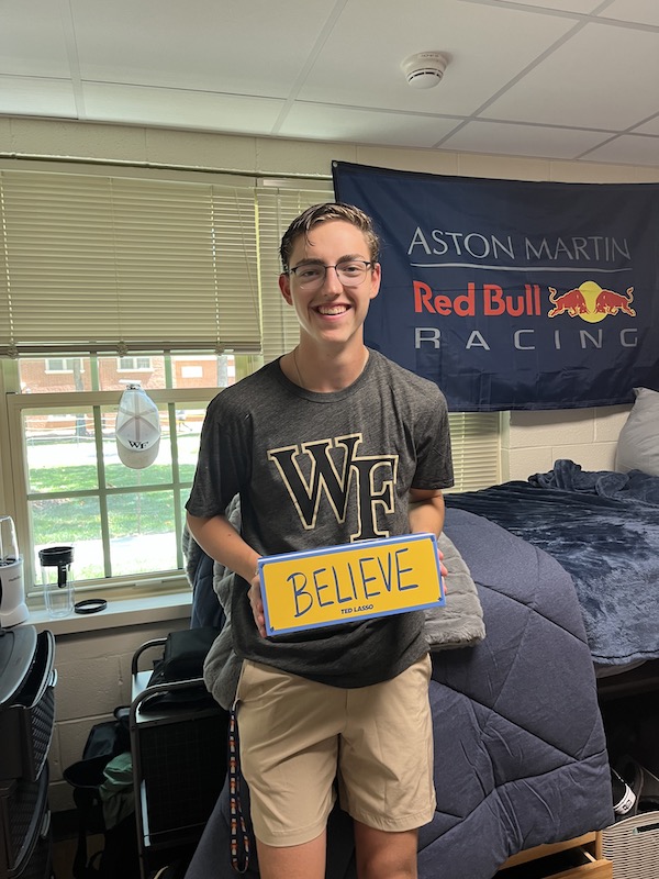 Carter McDonald holding his Ted Lasso "Believe" sign