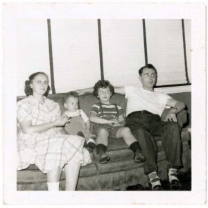 Black and white photo of the Baum family sitting on a couch
