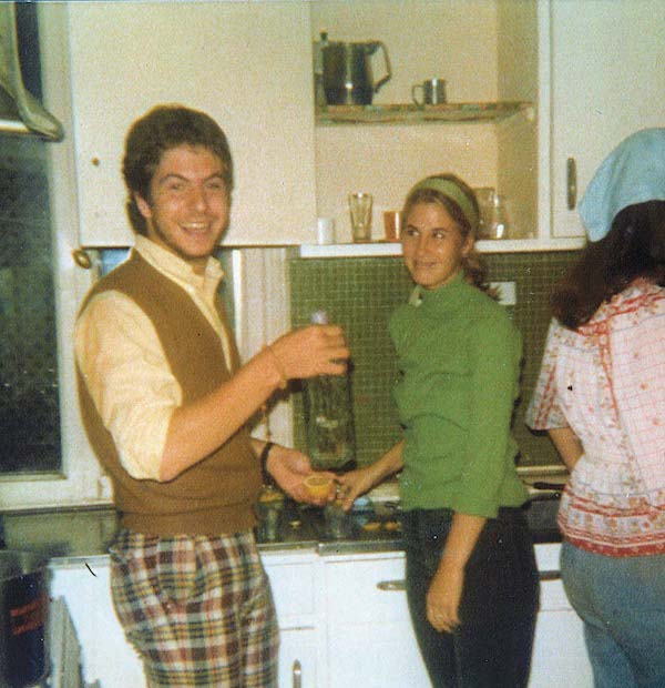 Students cooking in a kitchen in Venice. The kitchen has green tile.