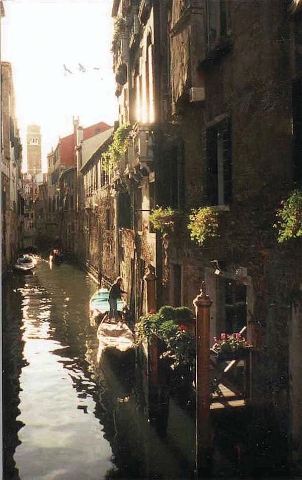 Light reflects off of windows and water on the Grand Canal.