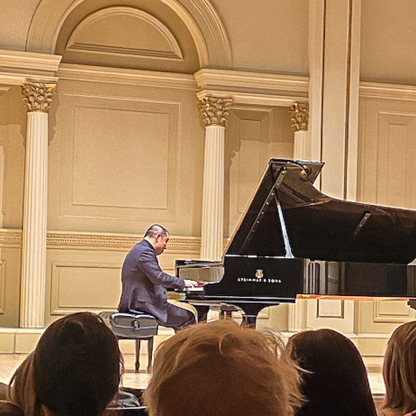 Larry Weng playing on a grand piano in Carnegie Hall