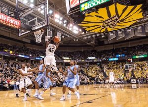 A basketball game in 2010. Tie Dye Wake Forest logo hangs off the scoreboard.