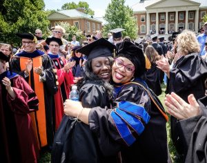 A professor and a graduate hug at Wake Forest's commencement ceremony in 2017